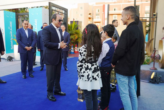 صورة تذكارية للرئيس السيسي مع مجموعة من الشباب خلال زيارته لمدينة الأسمرات